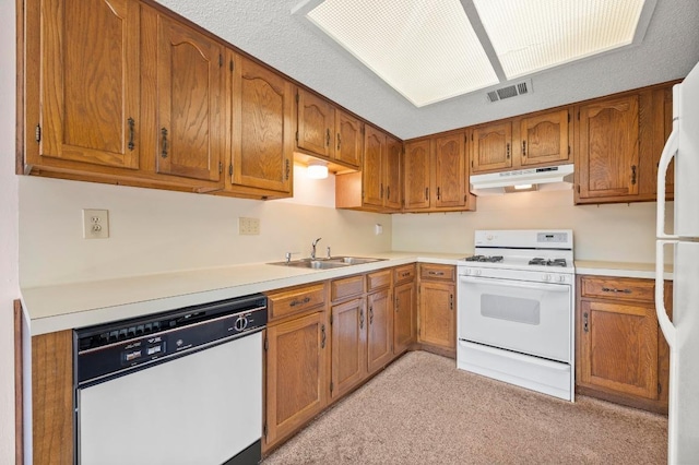 1046 Verbena Dr Unit 1474, Austin, TX 78750 - kitchen with white appliances, under cabinet range hood, a sink, and brown cabinetry