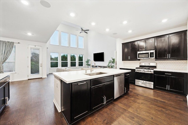 208 Carolina Jasmine Dr, San Marcos, TX 78666 - kitchen featuring appliances with stainless steel finishes, a sink, open floor plan, light countertops, and a center island with sink