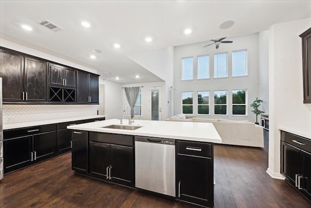 208 Carolina Jasmine Dr, San Marcos, TX 78666 - kitchen featuring stainless steel dishwasher, a sink, open floor plan, dark wood-type flooring, and an island with sink