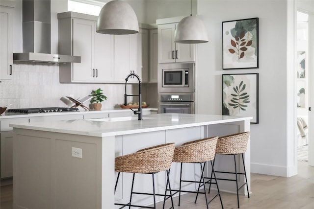 1809 Pasadena Dr, Austin, TX 78757 - kitchen featuring wall chimney exhaust hood, stainless steel appliances, a breakfast bar area, and a sink
