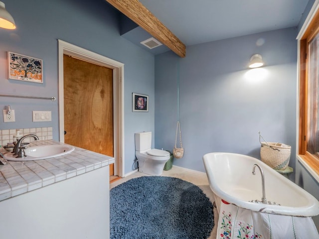 900 Pedernales Oaks Dr, Johnson City, TX 78636 - full bath featuring a freestanding tub, beamed ceiling, vanity, tasteful backsplash, and toilet