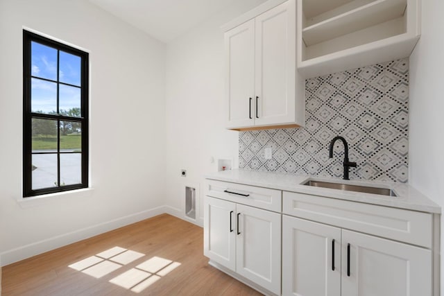 310 Apache Tears, Horseshoe Bay, TX 78657 - kitchen with a sink, backsplash, baseboards, light wood-style flooring, and light countertops