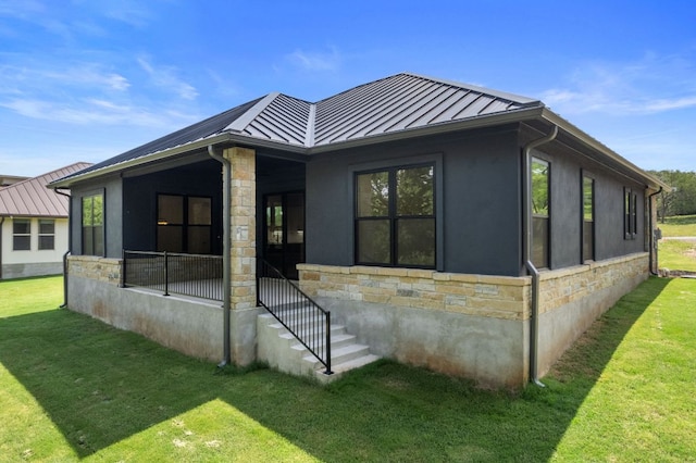 310 Apache Tears, Horseshoe Bay, TX 78657 - back of property with stone siding, a standing seam roof, and a yard
