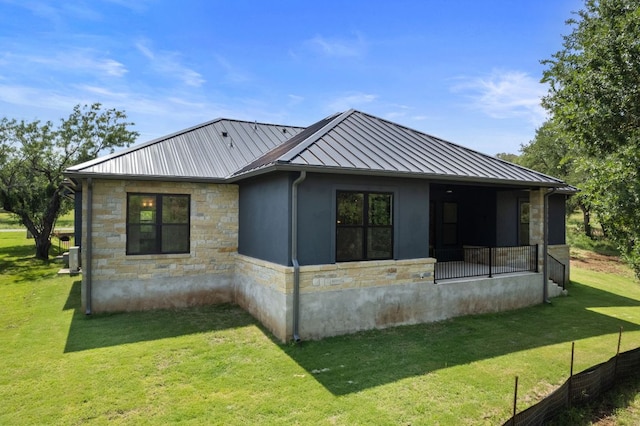 310 Apache Tears, Horseshoe Bay, TX 78657 - view of side of home with stone siding, a standing seam roof, metal roof, and a lawn