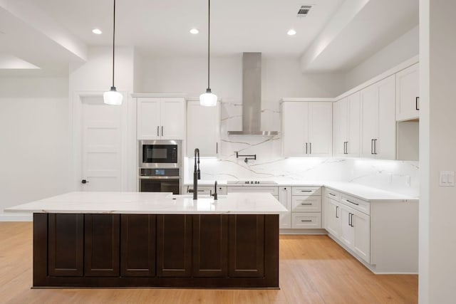 310 Apache Tears, Horseshoe Bay, TX 78657 - kitchen featuring oven, wall chimney range hood, built in microwave, a sink, and light wood-type flooring