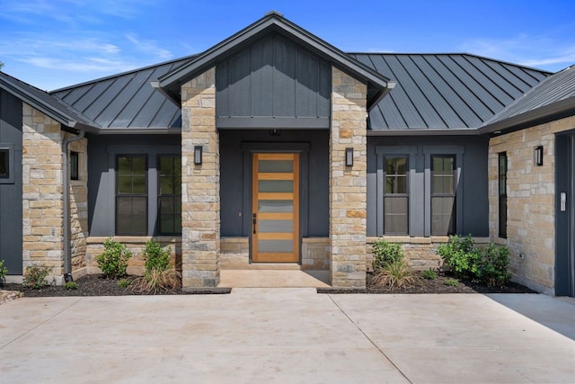 310 Apache Tears, Horseshoe Bay, TX 78657 - view of exterior entry with a standing seam roof, stone siding, metal roof, and a patio area