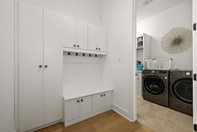 3417 Prairie Heights Dr, Leander, TX 78641 - washroom with washer and clothes dryer, cabinet space, light wood-type flooring, and baseboards
