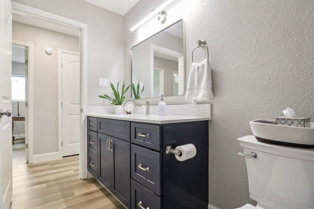 302 Martin Luther King St, Georgetown, TX 78626 - bathroom featuring wood finished floors, vanity, toilet, and baseboards