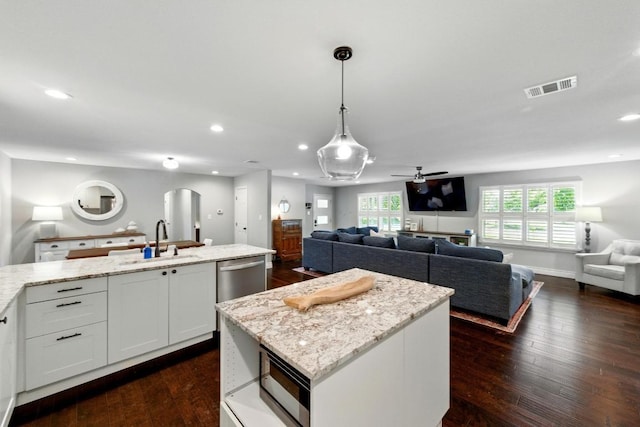 701 Nixon St, Lockhart, TX 78644 - kitchen featuring a sink, open floor plan, stainless steel dishwasher, a center island, and dark wood-style floors