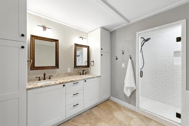 701 Nixon St, Lockhart, TX 78644 - bathroom featuring tiled shower, double vanity, and baseboards