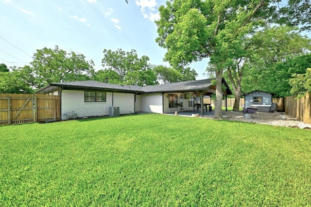 701 Nixon St, Lockhart, TX 78644 - rear view of property with central AC unit, brick siding, and a patio