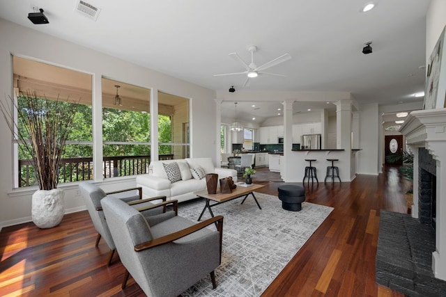 5804 Gentle Breeze Ter, Austin, TX 78731 - living room featuring a ceiling fan, dark wood-style flooring, a fireplace, decorative columns, and recessed lighting