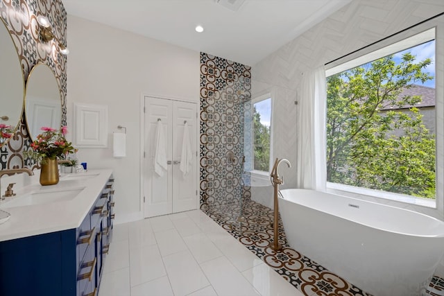 5804 Gentle Breeze Ter, Austin, TX 78731 - full bathroom featuring a soaking tub, double vanity, a tile shower, tile patterned floors, and recessed lighting