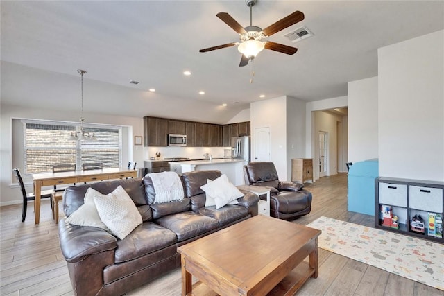 131 Mount Ellen St, Hutto, TX 78634 - living area with light wood-style floors, ceiling fan, vaulted ceiling, recessed lighting, and a chandelier