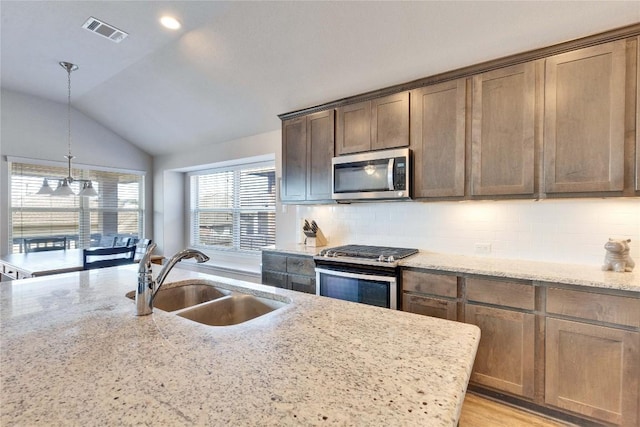131 Mount Ellen St, Hutto, TX 78634 - kitchen with stainless steel appliances, a sink, tasteful backsplash, light stone counters, and lofted ceiling