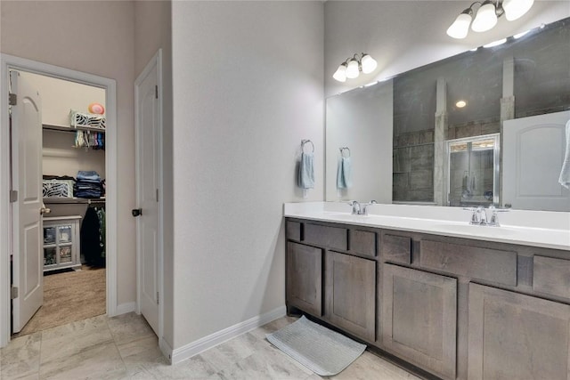 131 Mount Ellen St, Hutto, TX 78634 - full bathroom featuring double vanity, tiled shower, a spacious closet, and baseboards