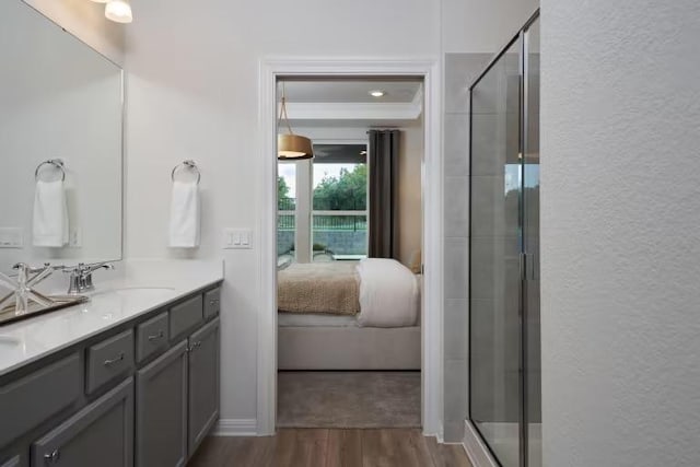 123 Crossbar St, Georgetown, TX 78633 - bathroom featuring connected bathroom, wood finished floors, a stall shower, vanity, and a textured wall