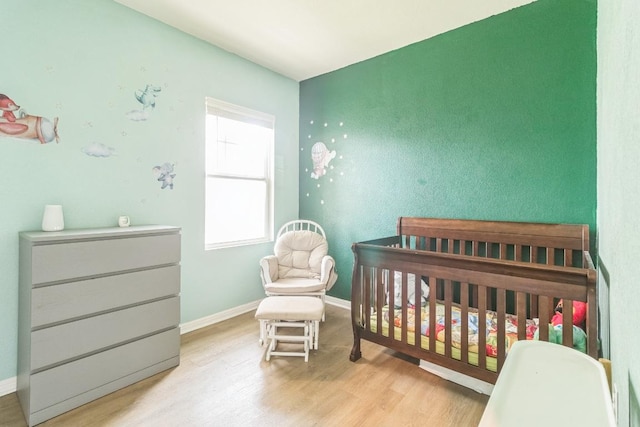 533 Peony Ct, Jarrell, TX 76537 - bedroom featuring wood finished floors, a nursery area, and baseboards