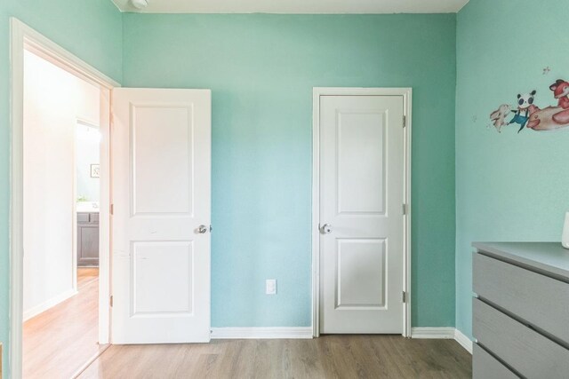 533 Peony Ct, Jarrell, TX 76537 - unfurnished bedroom with wood finished floors and baseboards