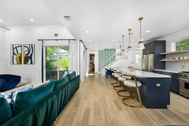 2002 E 8th St, Austin, TX 78702 - kitchen with stainless steel appliances, light countertops, open shelves, light wood-type flooring, and open floor plan