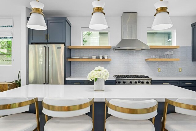 2002 E 8th St, Austin, TX 78702 - kitchen featuring appliances with stainless steel finishes, open shelves, light countertops, decorative backsplash, and wall chimney range hood