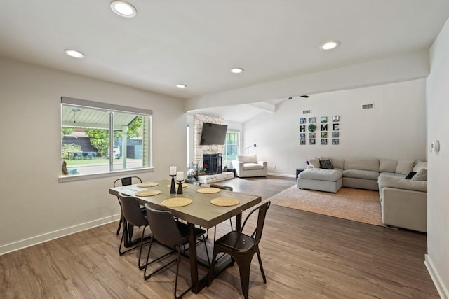 12308 Wycliff Ln, Austin, TX 78727 - dining area with a stone fireplace, wood finished floors, and recessed lighting