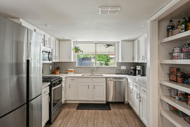 12308 Wycliff Ln, Austin, TX 78727 - kitchen featuring stainless steel appliances, white cabinets, light countertops, and decorative backsplash