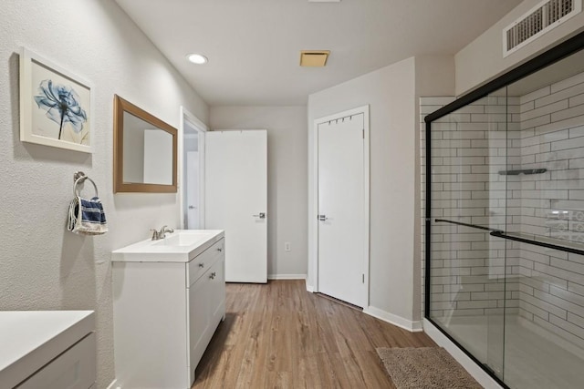 12308 Wycliff Ln, Austin, TX 78727 - bathroom with vanity, a stall shower, wood finished floors, and recessed lighting