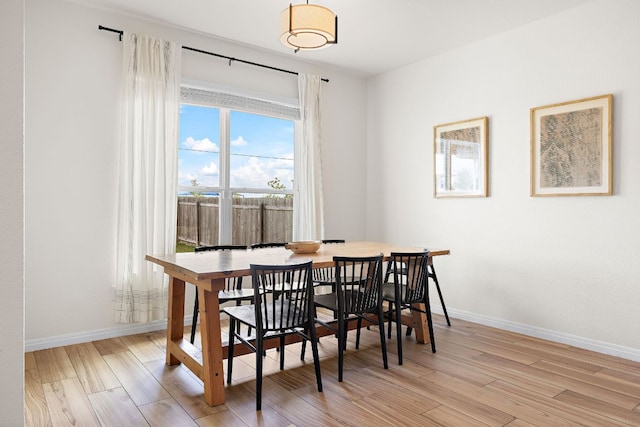 dining area with light wood finished floors and baseboards
