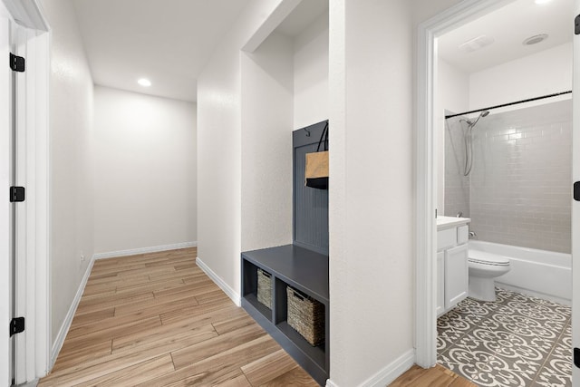 full bathroom featuring toilet, vanity, wood finished floors, shower / bathtub combination, and recessed lighting