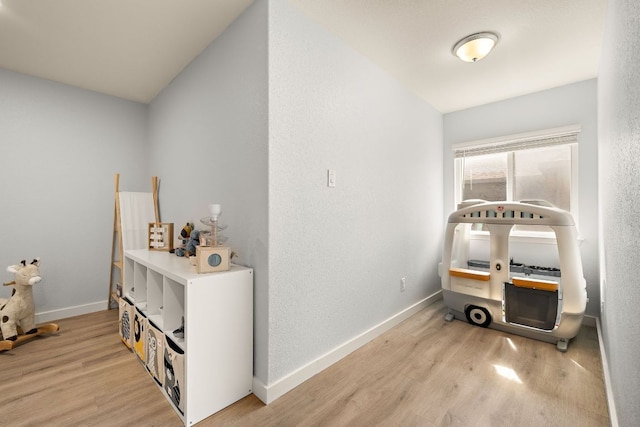hall with light wood-type flooring and baseboards