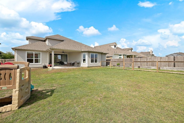 rear view of property with ceiling fan, a patio area, and a shingled roof