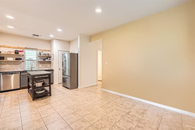 129 Bosque Dr, San Marcos, TX 78666 - kitchen featuring appliances with stainless steel finishes, open shelves, recessed lighting, light tile patterned floors, and decorative backsplash
