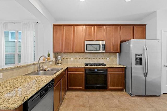 1121 Salem Park Ct, Austin, TX 78745 - kitchen featuring black appliances, a sink, brown cabinetry, and light stone counters