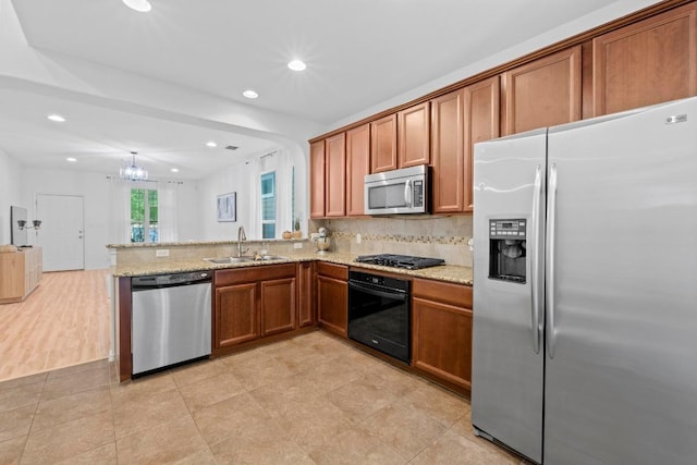 1121 Salem Park Ct, Austin, TX 78745 - kitchen featuring black appliances, a sink, brown cabinetry, recessed lighting, and light stone counters