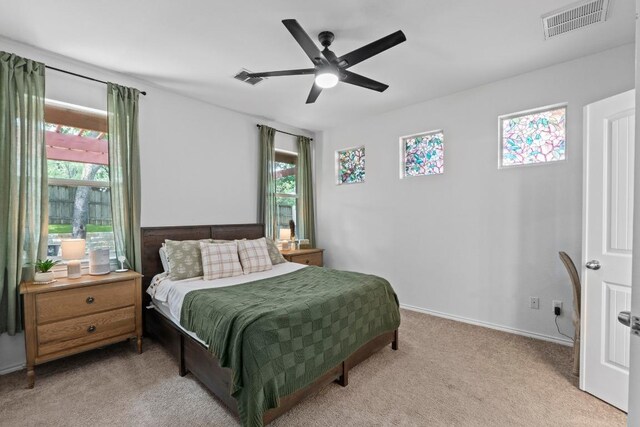1121 Salem Park Ct, Austin, TX 78745 - bedroom with multiple windows, light colored carpet, a ceiling fan, and baseboards