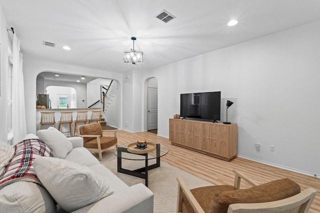 1121 Salem Park Ct, Austin, TX 78745 - living room with arched walkways, light wood-type flooring, stairway, recessed lighting, and baseboards
