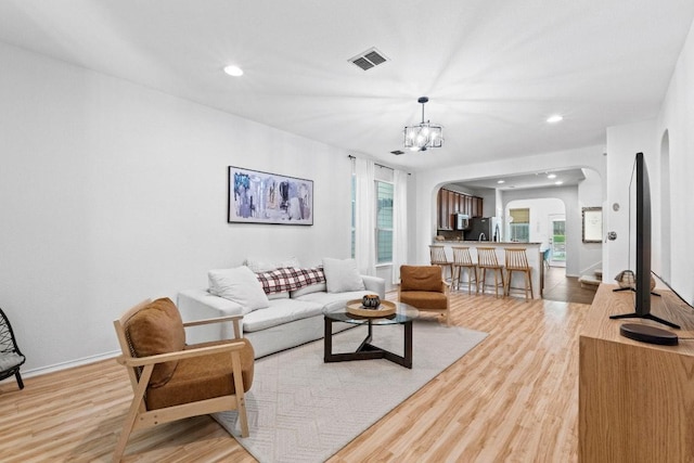 1121 Salem Park Ct, Austin, TX 78745 - living room with arched walkways, wood finished floors, a chandelier, recessed lighting, and baseboards