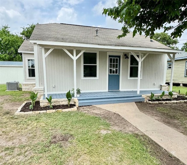 713 N Polk St, Giddings, TX 78942 - view of front of property featuring central air condition unit, covered porch, and a front lawn