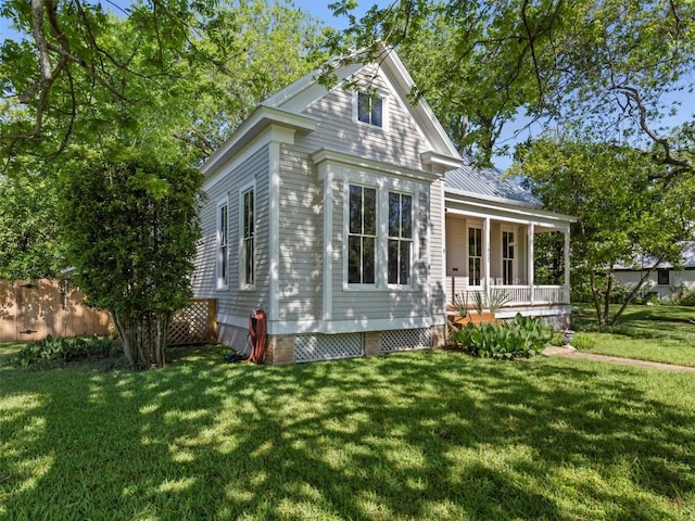 view of side of property featuring covered porch and a yard