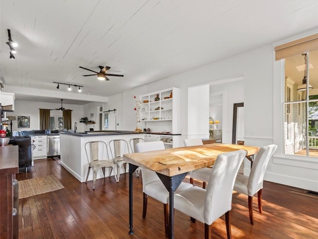 dining space with a ceiling fan, dark wood finished floors, and rail lighting