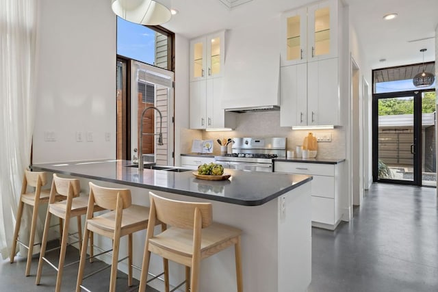 607 Terrell Hill Dr Unit B, Austin, TX 78704 - kitchen featuring stainless steel gas range, dark countertops, decorative backsplash, a sink, and a kitchen bar
