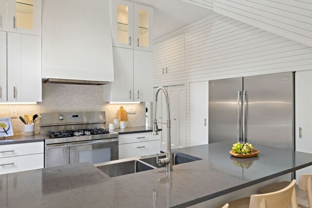 607 Terrell Hill Dr Unit B, Austin, TX 78704 - kitchen with stainless steel appliances, white cabinets, tasteful backsplash, and a kitchen breakfast bar