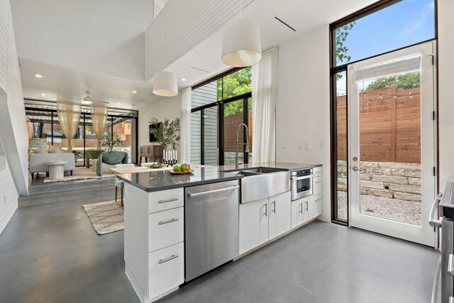 607 Terrell Hill Dr Unit B, Austin, TX 78704 - kitchen featuring dishwasher, finished concrete flooring, healthy amount of natural light, dark countertops, and recessed lighting