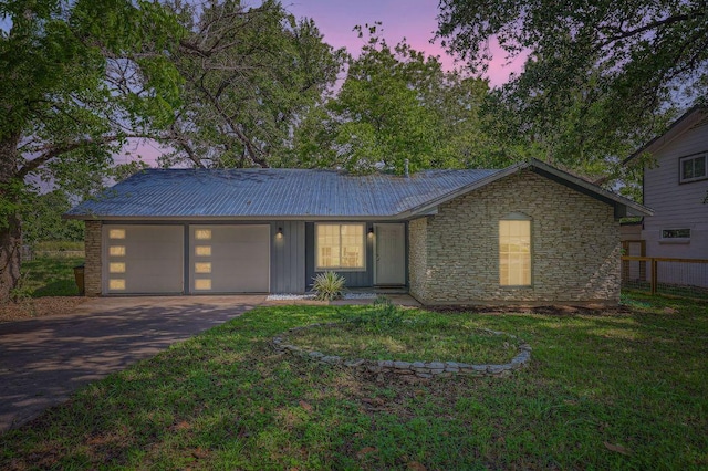 906 Hermitage Dr, Austin, TX 78753 - view of front facade with driveway, an attached garage, stone siding, and metal roof