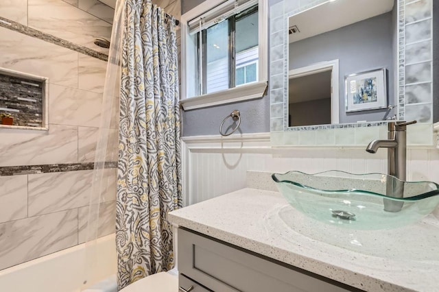 906 Hermitage Dr, Austin, TX 78753 - bathroom featuring shower / bath combination with curtain, vanity, and wainscoting