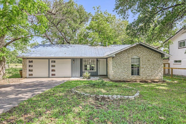 906 Hermitage Dr, Austin, TX 78753 - single story home with a garage, driveway, stone siding, a metal roof, and board and batten siding