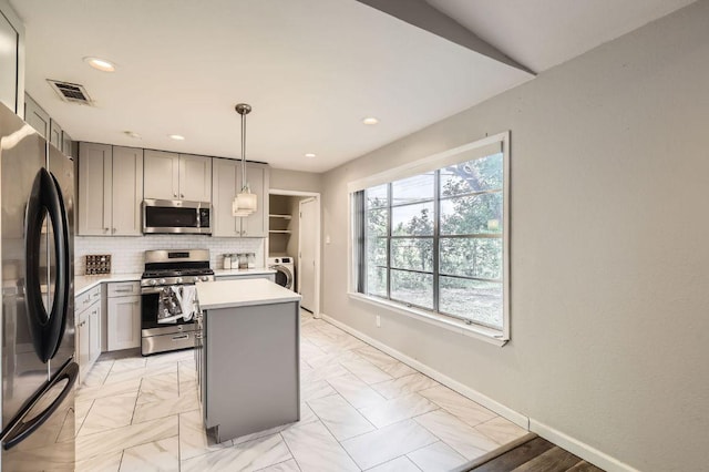 906 Hermitage Dr, Austin, TX 78753 - kitchen with stainless steel appliances, gray cabinetry, light countertops, tasteful backsplash, and a kitchen island