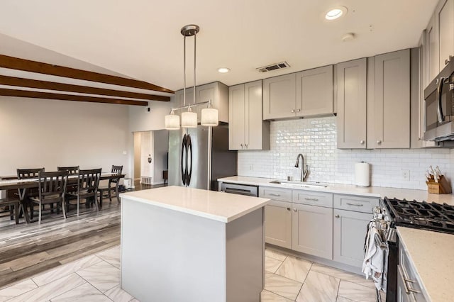906 Hermitage Dr, Austin, TX 78753 - kitchen featuring a sink, stainless steel appliances, gray cabinetry, a kitchen island, and light countertops
