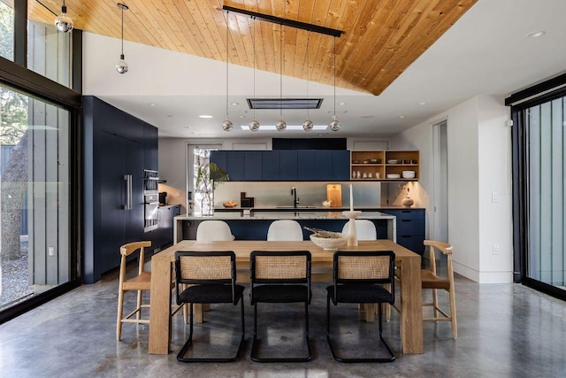 kitchen with concrete floors, a sink, pendant lighting, lofted ceiling, and modern cabinets